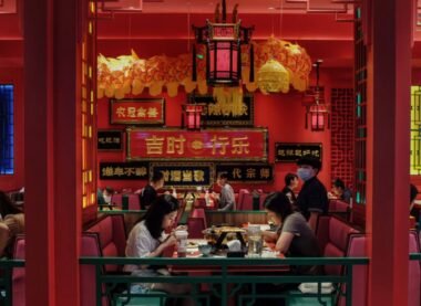 Modern Chinese restaurant interior with red and gold décor, traditional lanterns, and diners enjoying authentic Chinese cuisine.