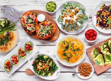 Colorful vegan dishes served on a table, featuring salads, avocado, noodles, and roasted vegetables at vegan restaurants in the USA.
