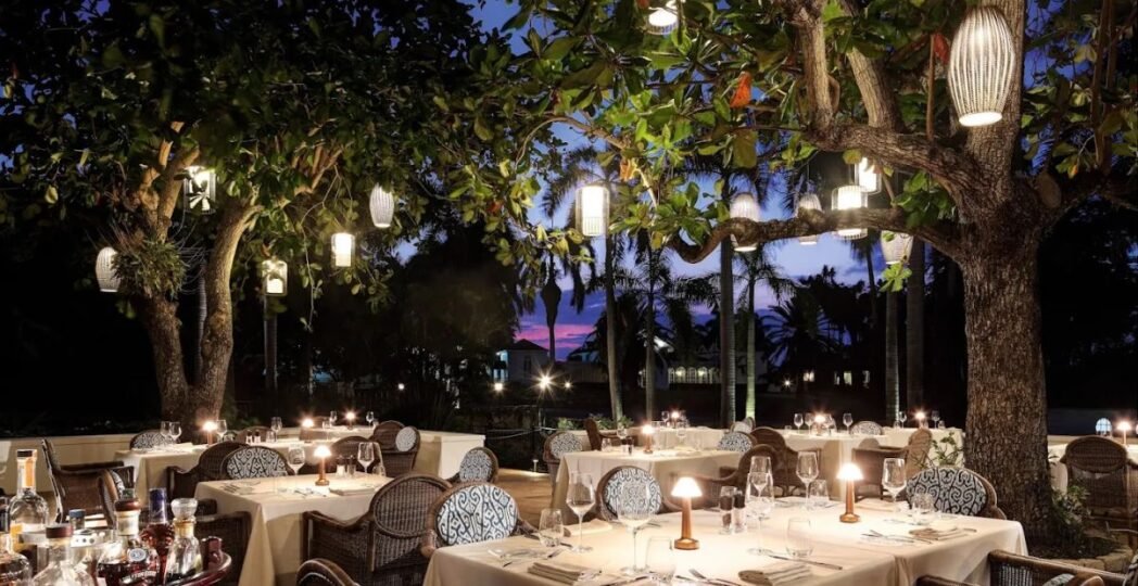 Outdoor dining area at one of the best Mexican restaurants with cozy lighting and elegant table settings under trees.