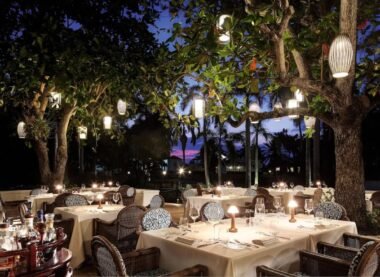 Outdoor dining area at one of the best Mexican restaurants with cozy lighting and elegant table settings under trees.