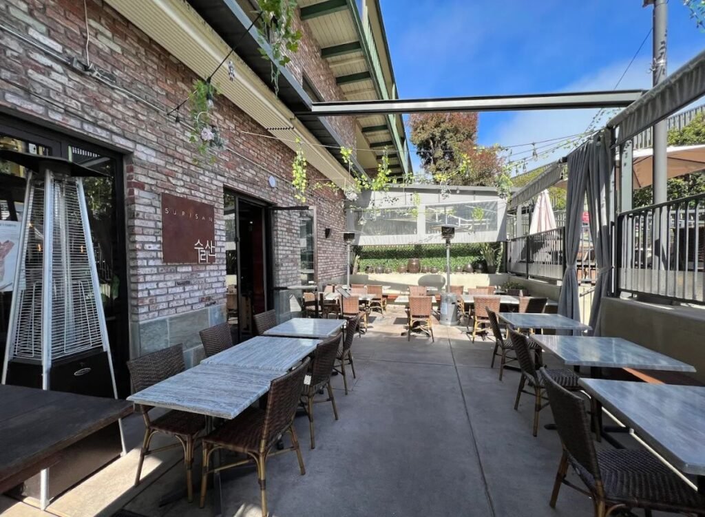 Assorted Asian breakfast foods with rice porridge, buns, and tea